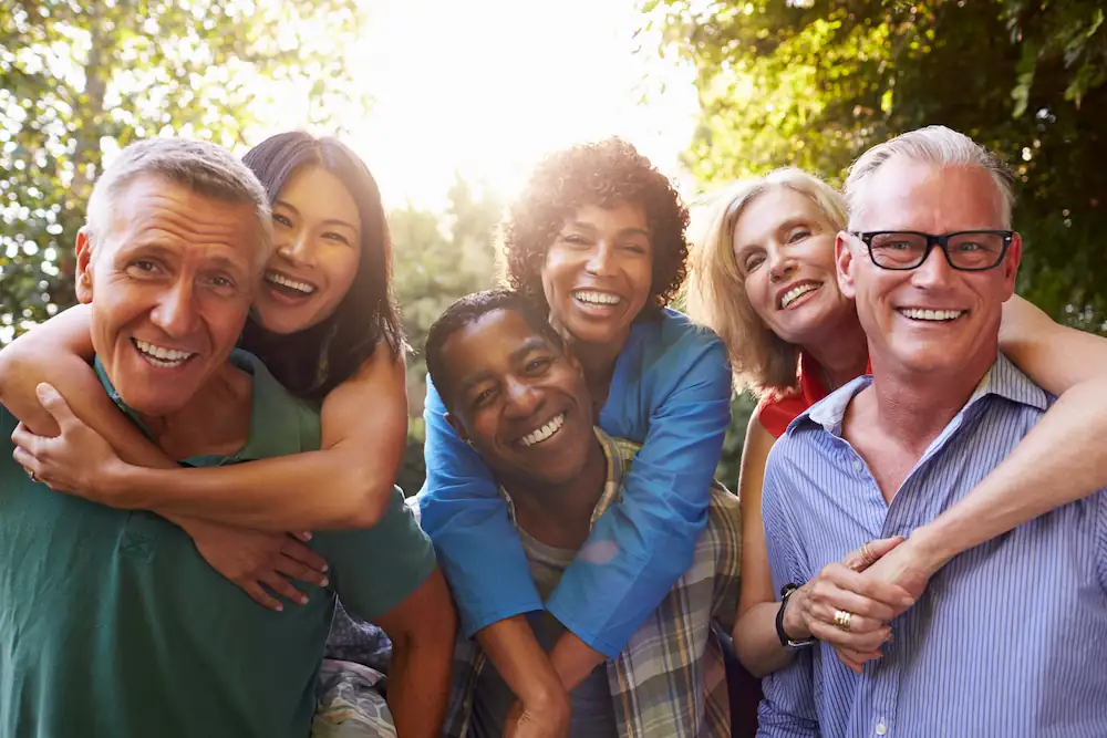 Group of older couples hugging their spouses happily